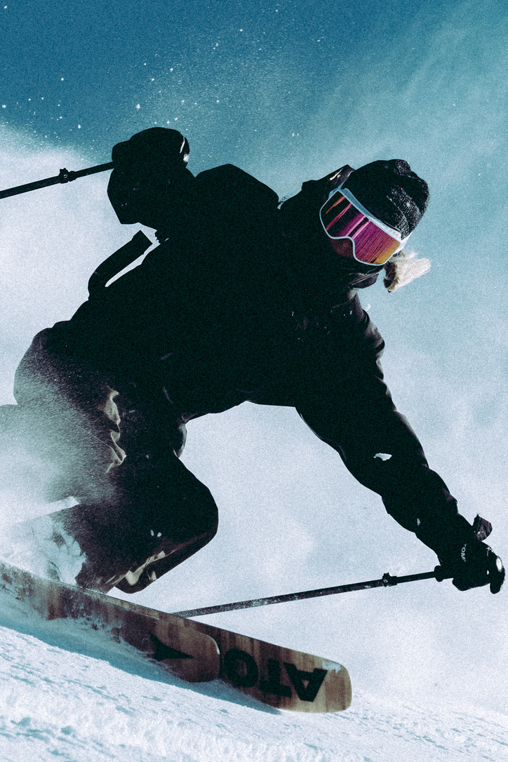 Skier carving through snow beneath a blue sky for the Arc’teryx ABA Hero campaign