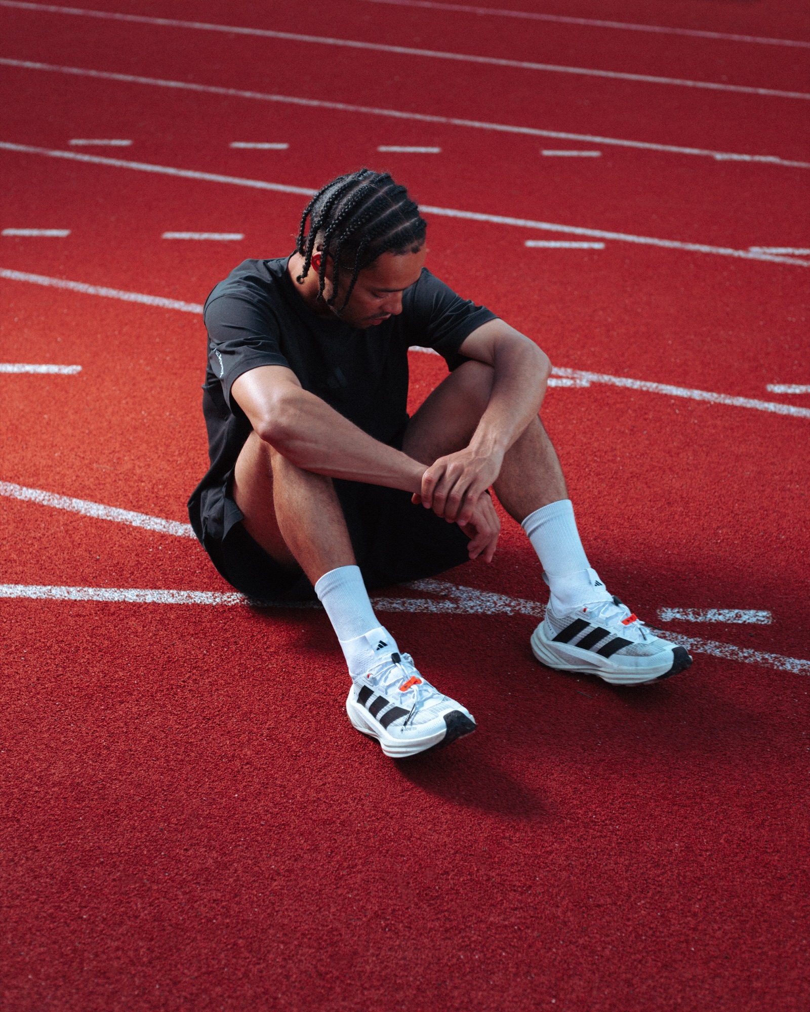 Adidas Terrex athlete resting on a red running track during the Freehiker photography campaign
